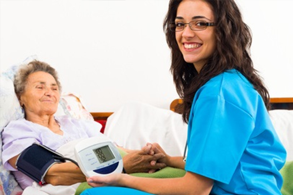 Nurse using digital blood pressure for senior patient
